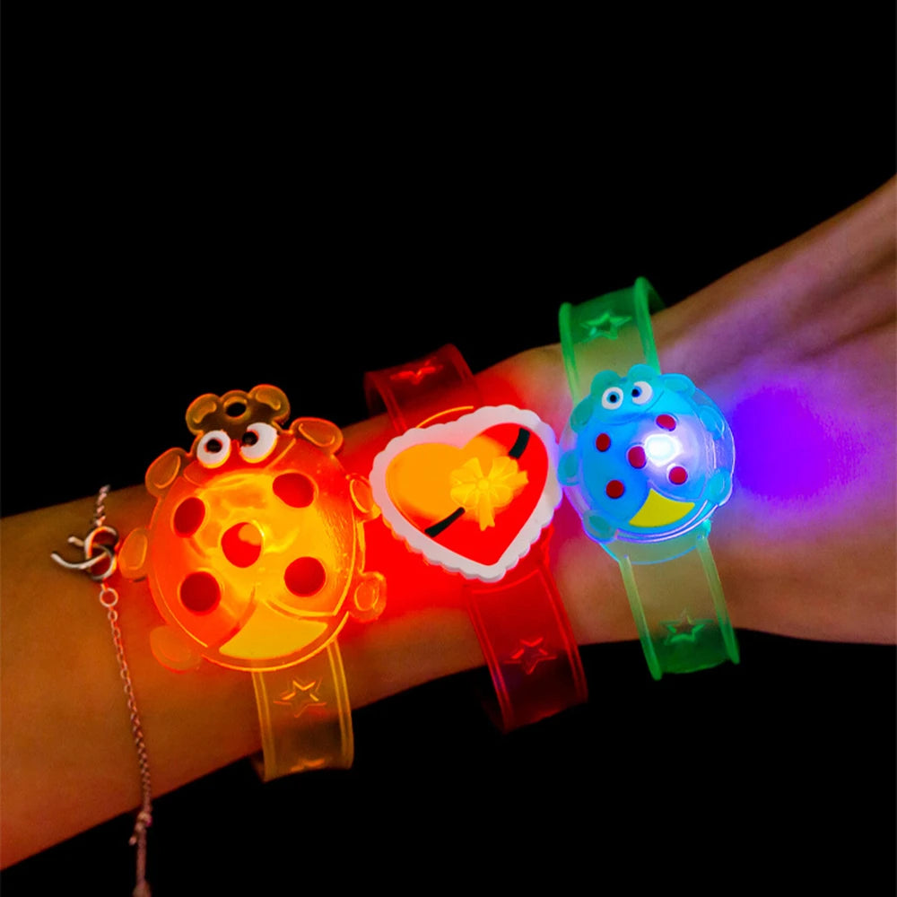Kids LED glow wrist watches on arm: orange bug, heart, and green-blue character designs.