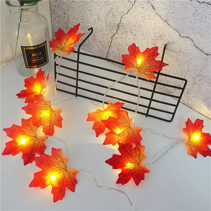 LED maple leaf lantern string lights with warm orange glow and red-orange leaf lanterns