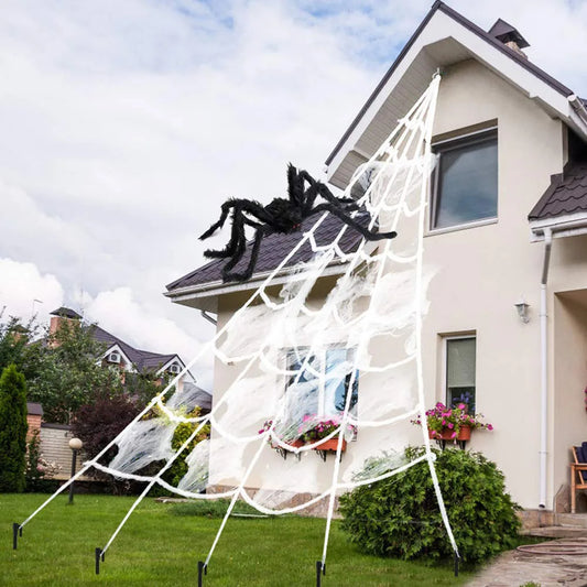 Large white triangle spider web decor with black spider on a house exterior