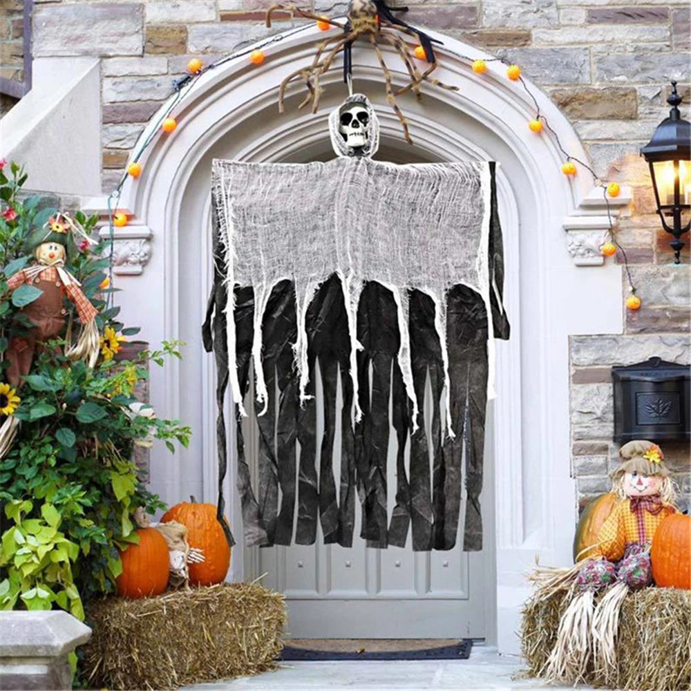 Hanging skull prop draped on front door, gray ghost sheet with dangling bone legs