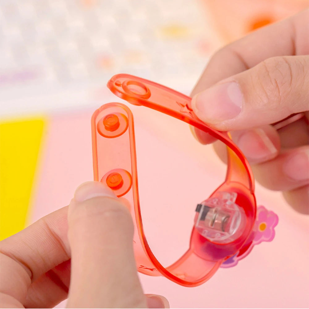 Orange LED kids wrist watch held open, showing clear LED bulb and hinged strap clip.