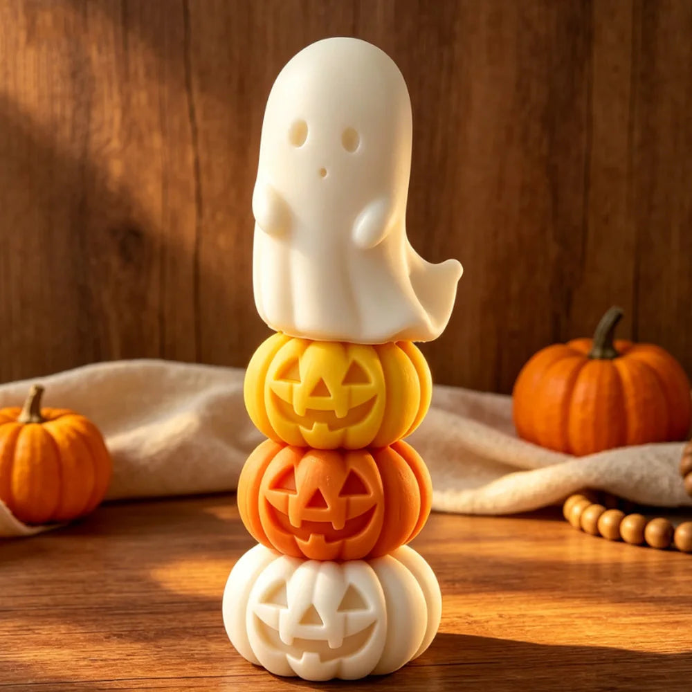 Stacked white ghost and orange jack-o’-lantern candle figures on a table