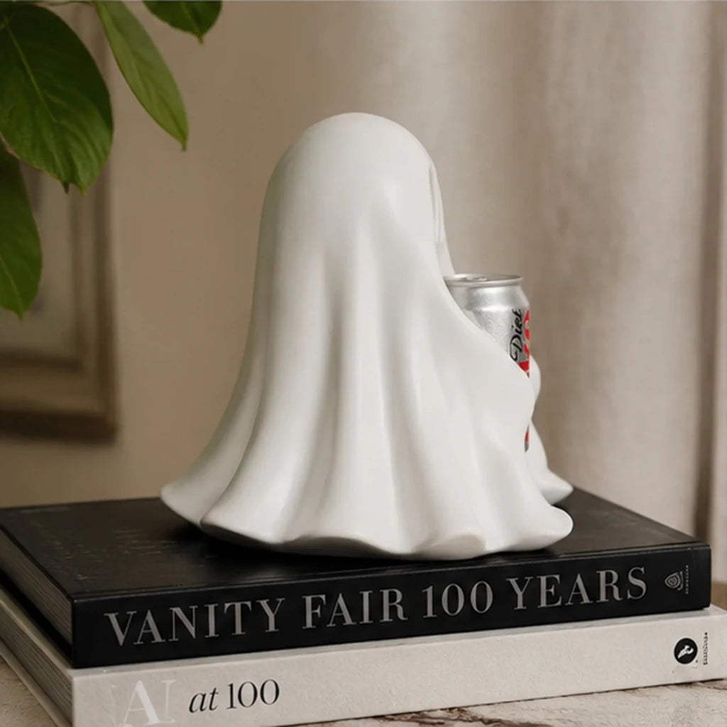 White ghost resin statue holding a silver soda can with red label on stacked books.
