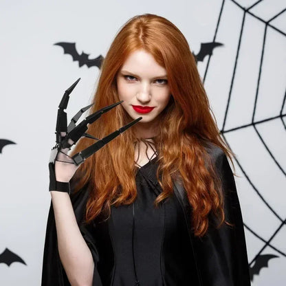 Black articulated finger claw glove held up near face with long pointed claws