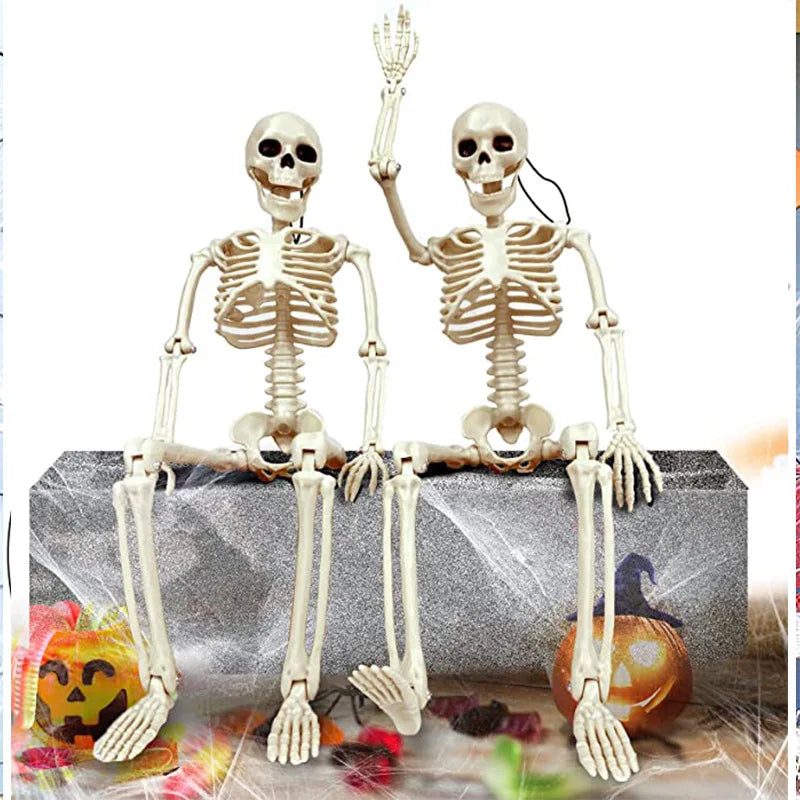 Pair of white skeleton props seated on gray stone, Halloween decoration