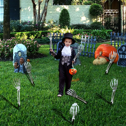 Skeleton hand garden stakes planted in green lawn beside yard Halloween decor