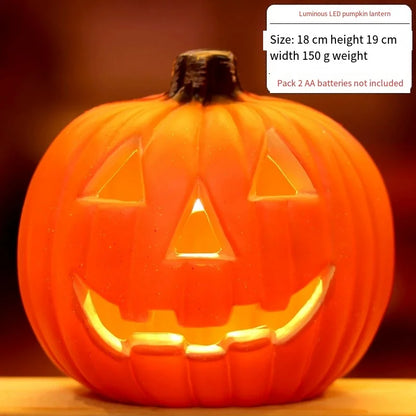 Orange LED pumpkin lantern with carved jack-o'-lantern grin, warm light glowing