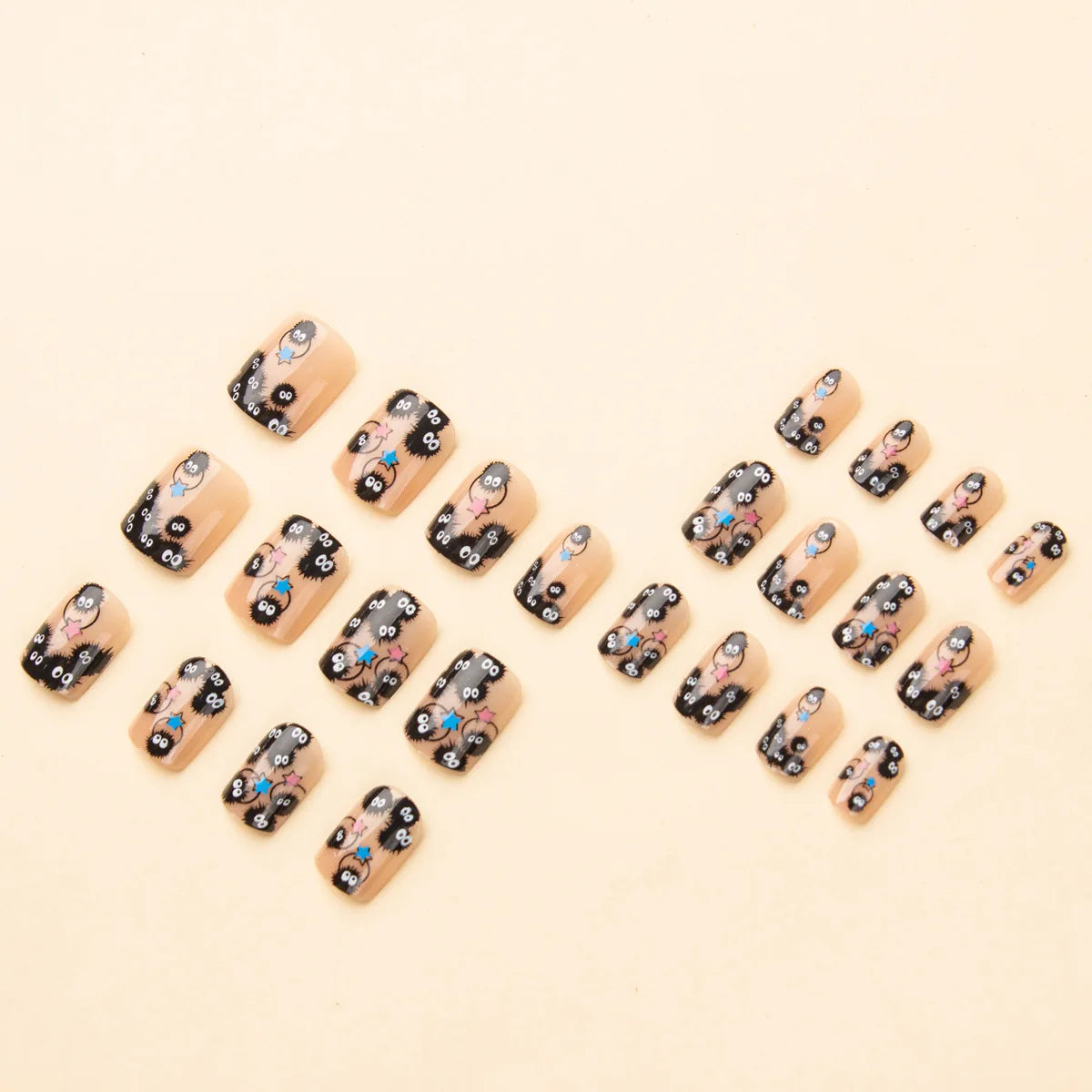 Square short fake nails arranged in a cluster; black designs with cute characters
