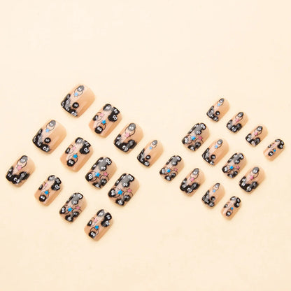 Square short fake nails arranged in a cluster; black designs with cute characters