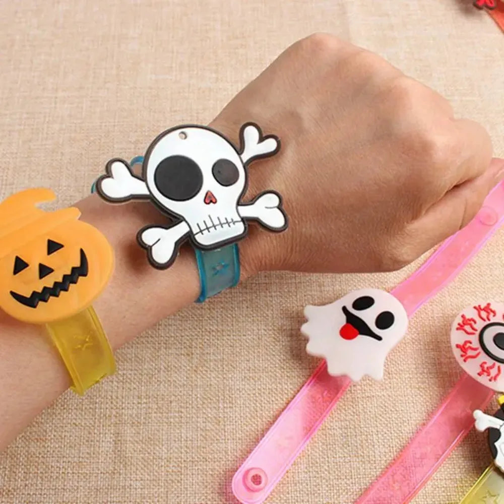 Kids' wrist wearing glow-in-the-dark Halloween bracelets with skull and pumpkin charms