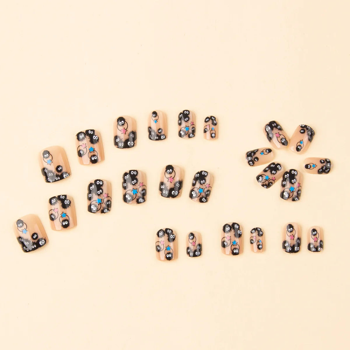 Square short press-on nails with black designs and small blue and pink star details