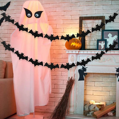 Paper bat hanging garland decoration with black bats across a party display